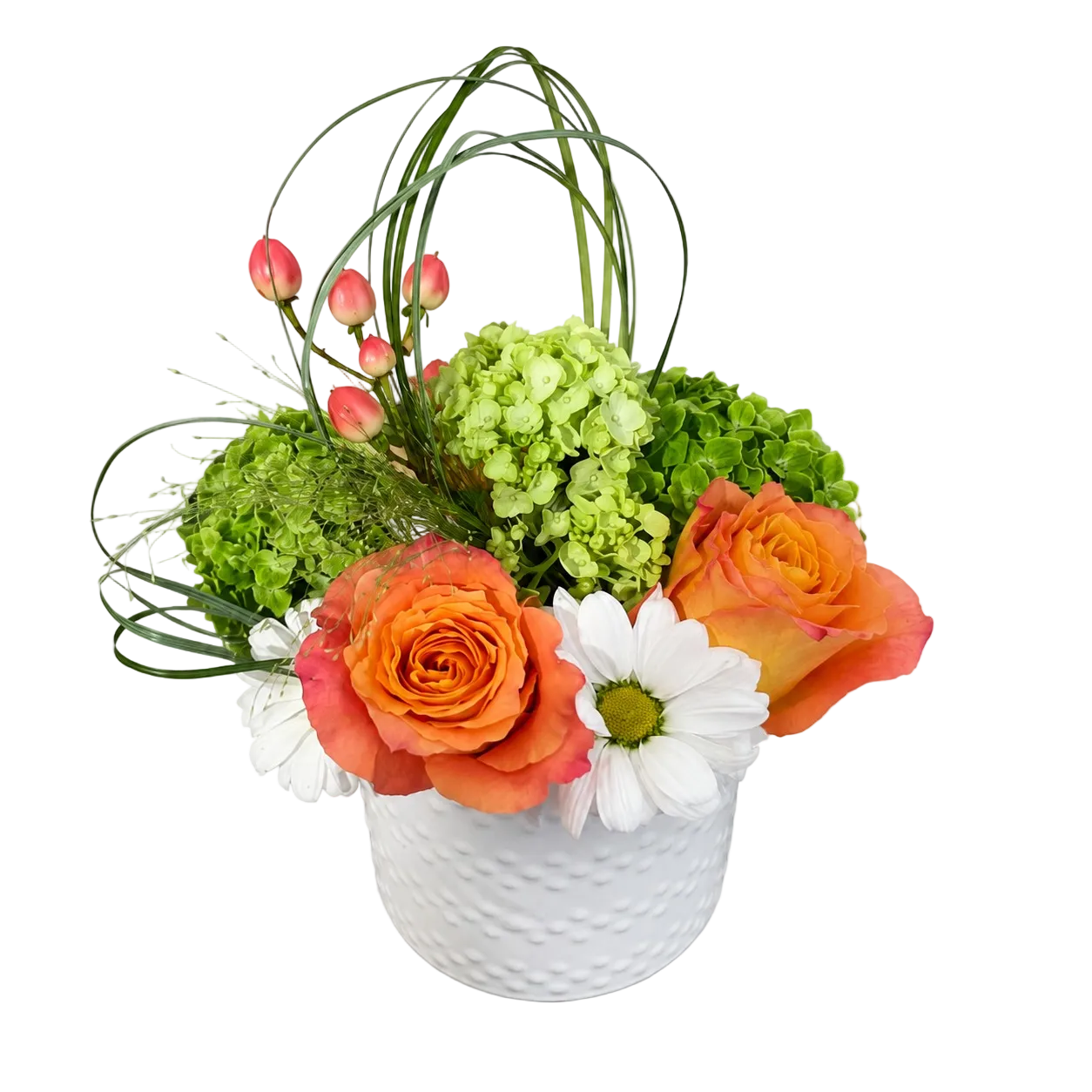 A floral arrangement in a white textured ceramic pot, featuring orange roses, green hydrangeas, white daisies, pink tulip buds, and green ornamental grasses on a white background.